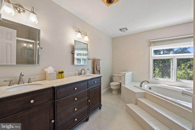 bathroom featuring vanity, a relaxing tiled tub, tile patterned floors, and toilet