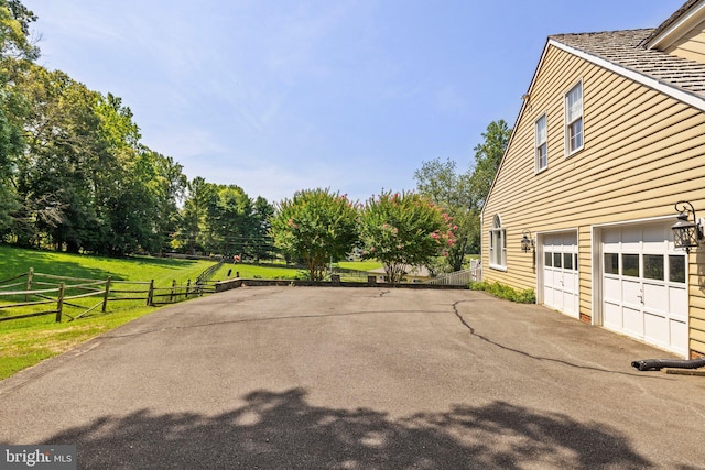 view of property exterior with a garage and a yard