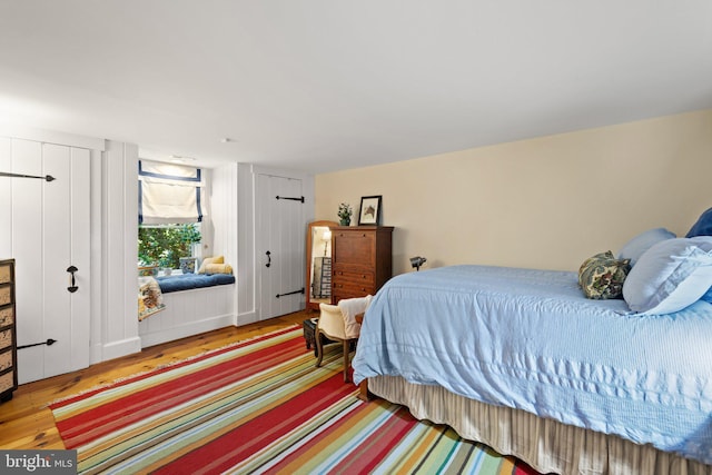 bedroom with hardwood / wood-style flooring and two closets