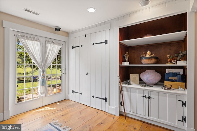 doorway to outside with light hardwood / wood-style floors and a wealth of natural light