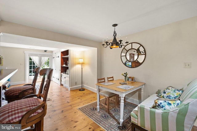 dining area featuring an inviting chandelier and light hardwood / wood-style flooring