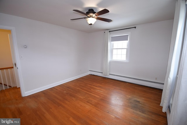 spare room with a baseboard heating unit, hardwood / wood-style floors, and ceiling fan