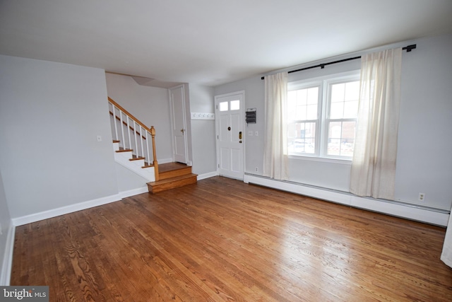 foyer entrance with hardwood / wood-style flooring, a baseboard radiator, and a wealth of natural light