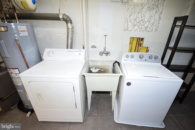 laundry room with dark tile patterned floors, electric water heater, and washer and clothes dryer