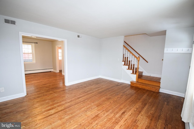 unfurnished room with hardwood / wood-style floors and a baseboard radiator