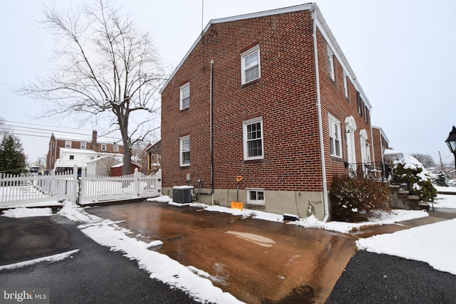 view of snowy exterior featuring central AC