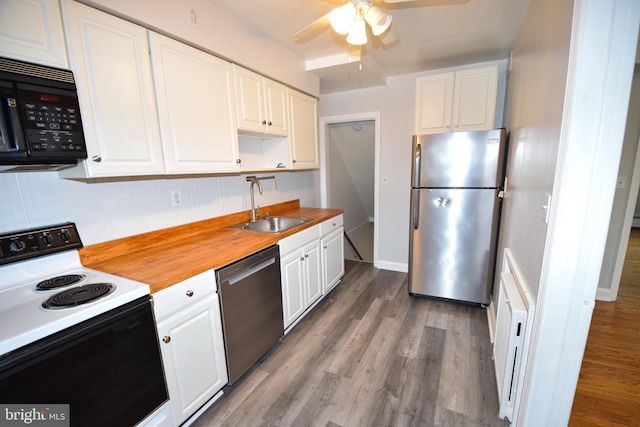 kitchen featuring butcher block counters, electric range, stainless steel fridge, dishwasher, and white cabinets