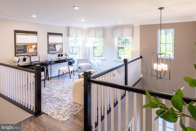 stairs with crown molding, a chandelier, and hardwood / wood-style floors