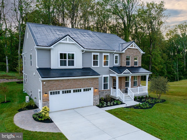 view of front of house featuring a garage, a yard, and covered porch