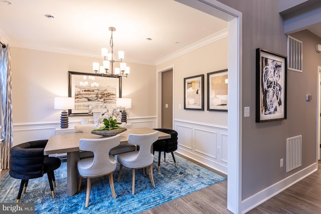 dining area with a chandelier, crown molding, and wood-type flooring