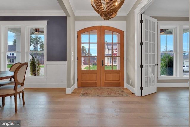 foyer entrance featuring light hardwood / wood-style flooring, french doors, and crown molding