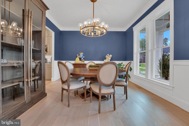 dining room with a chandelier, ornamental molding, and light hardwood / wood-style floors