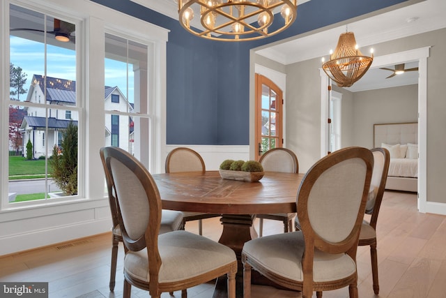 dining room featuring light wood-type flooring, an inviting chandelier, and ornamental molding