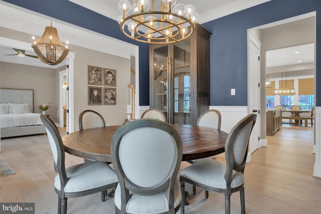 dining area with light wood-type flooring, a chandelier, and crown molding