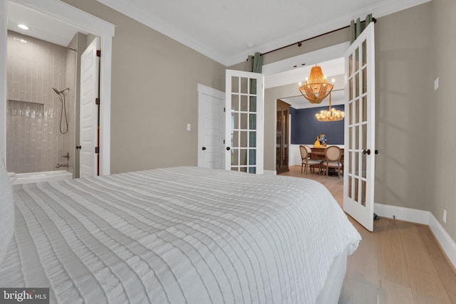 bedroom with a notable chandelier, ornamental molding, french doors, and light wood-type flooring