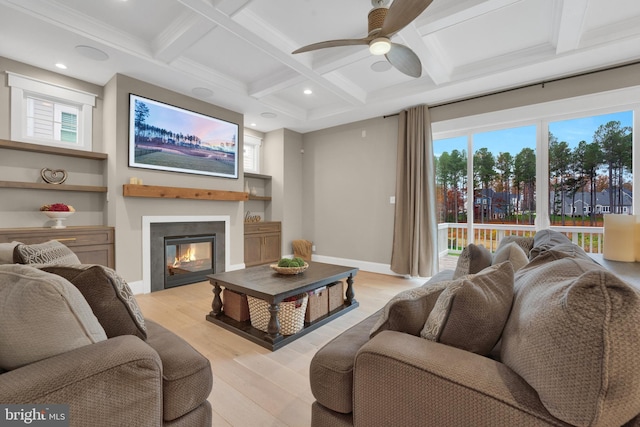 living room featuring ornamental molding, ceiling fan, light hardwood / wood-style flooring, beam ceiling, and coffered ceiling