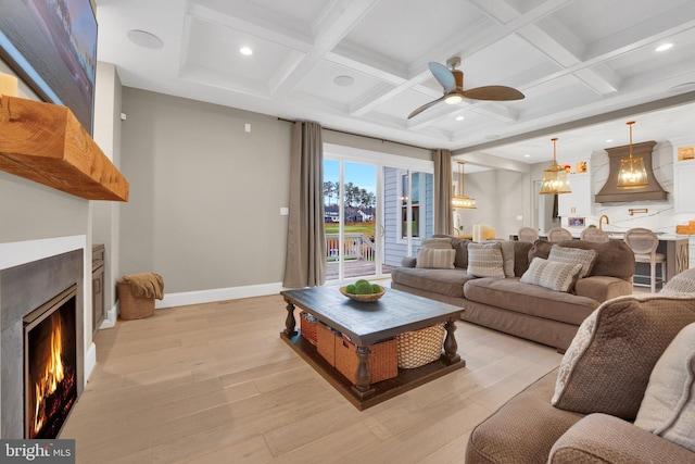 living room with coffered ceiling, light hardwood / wood-style flooring, beam ceiling, and ceiling fan