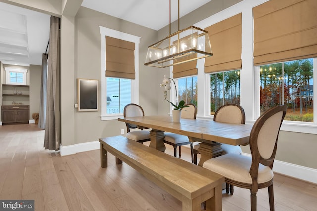 dining room featuring light wood-type flooring, an inviting chandelier, and plenty of natural light