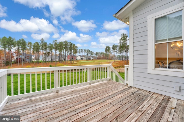 wooden terrace featuring a lawn