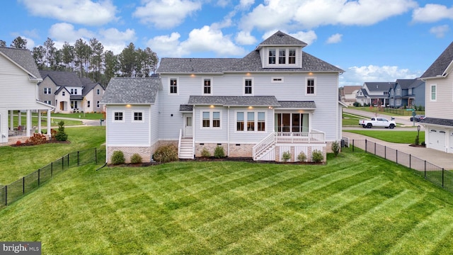 rear view of property featuring a lawn