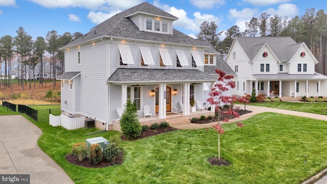 view of front of home with a front lawn, a porch, and central AC