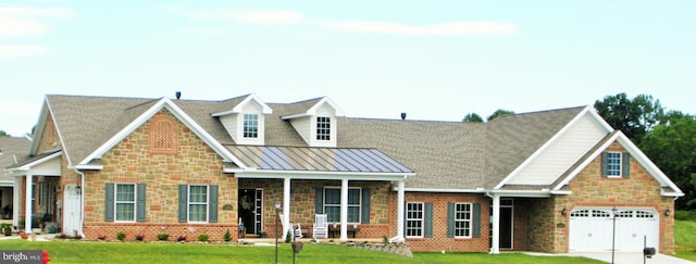 view of front of house with a garage, a front yard, and a porch