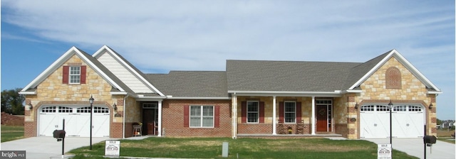 view of front of home with a front lawn, a garage, and covered porch