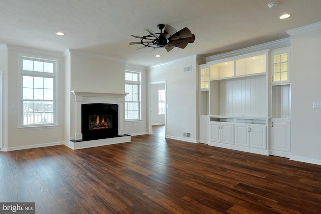 unfurnished living room featuring ceiling fan, crown molding, and dark hardwood / wood-style floors