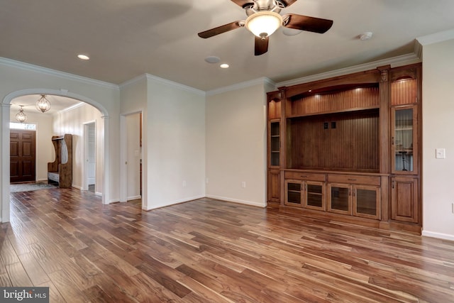 unfurnished living room featuring hardwood / wood-style flooring, crown molding, and ceiling fan