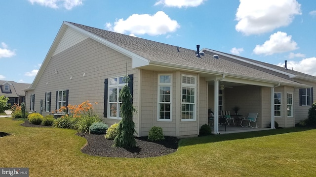 rear view of property featuring a yard and a patio