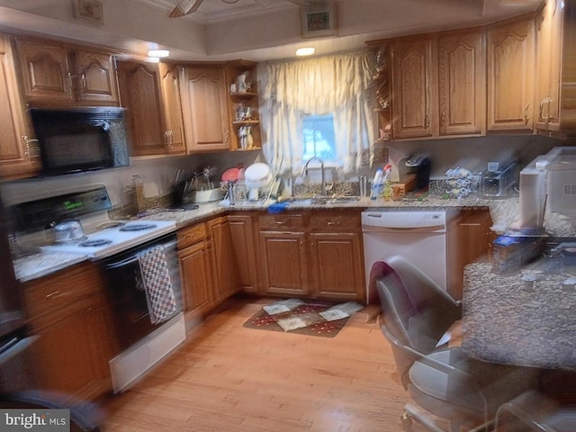 kitchen featuring sink, white appliances, light hardwood / wood-style flooring, and light stone counters