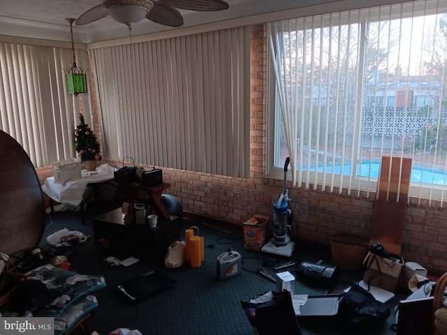 miscellaneous room featuring plenty of natural light, brick wall, and ceiling fan