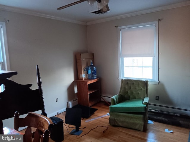 living area featuring hardwood / wood-style flooring, a baseboard heating unit, and ornamental molding