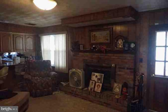 living room featuring a brick fireplace and a healthy amount of sunlight