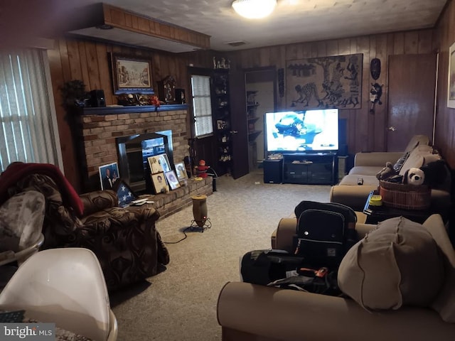 carpeted living room with wood walls and a fireplace