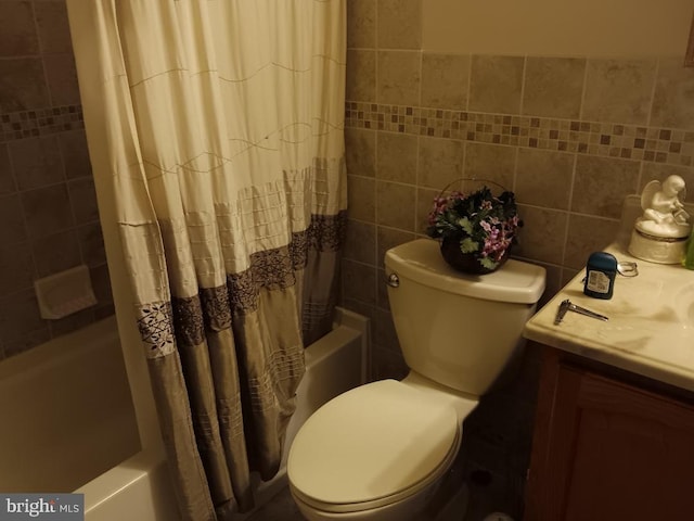 full bathroom with tile walls, toilet, vanity, and shower / bath combination with curtain