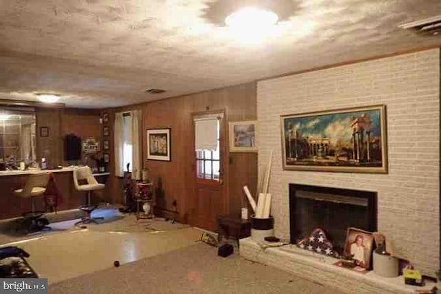 unfurnished living room with a fireplace and wood walls