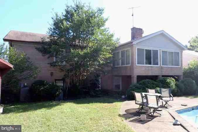 back of house with a lawn and a patio