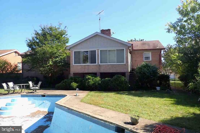 back of house featuring a fenced in pool and a yard