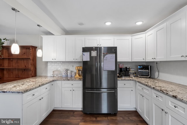 kitchen featuring white cabinetry and stainless steel refrigerator