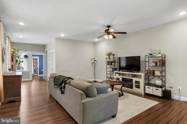 living room featuring ceiling fan and dark hardwood / wood-style flooring