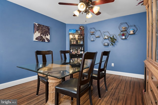 dining space with ceiling fan and dark hardwood / wood-style flooring