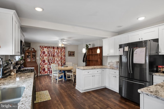 kitchen featuring pendant lighting, white cabinets, fridge, and dark wood-type flooring