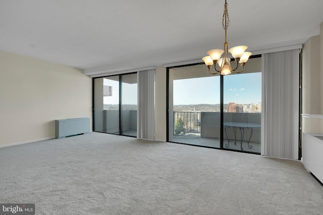 carpeted spare room with floor to ceiling windows and a chandelier