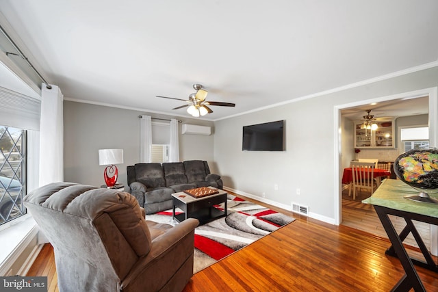 living room with ceiling fan, ornamental molding, hardwood / wood-style floors, and a wall unit AC