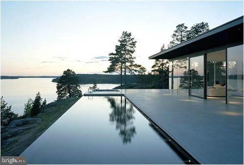 pool at dusk featuring a water view