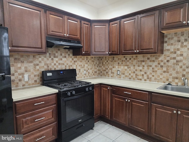 kitchen with black appliances, backsplash, dark brown cabinetry, and sink