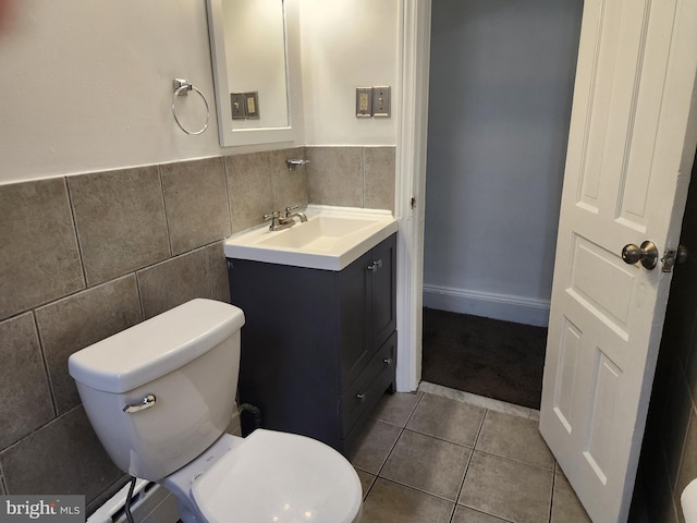 bathroom with tile walls, tile patterned floors, vanity, and toilet