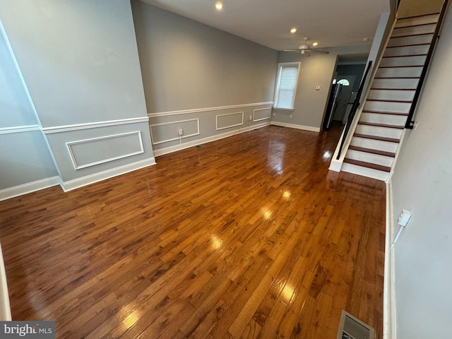 unfurnished living room featuring ceiling fan and dark hardwood / wood-style flooring