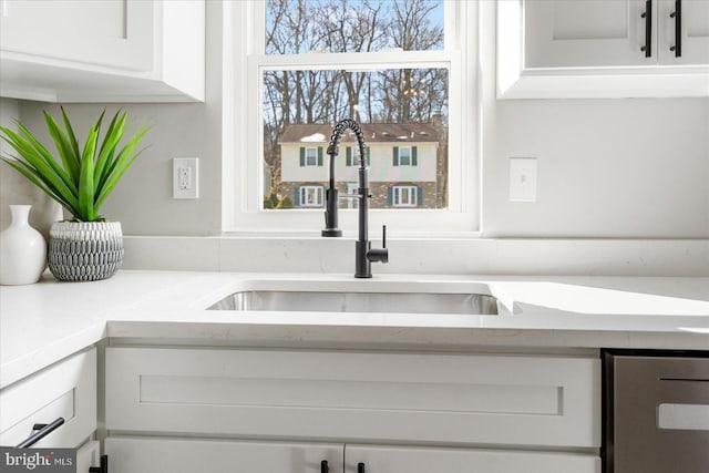 details featuring white cabinetry, sink, and light stone counters